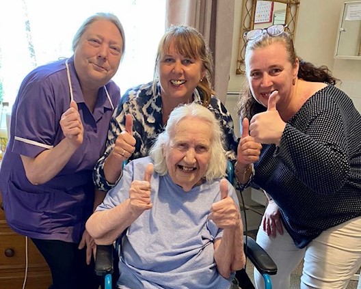 meet some of the happy, smiling family. Thumbs up from a resident and some staff.